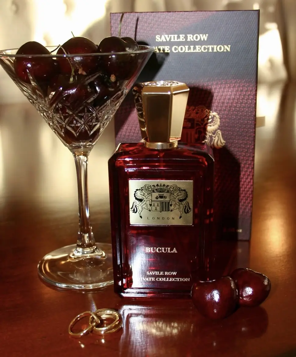 Bucula Extrait de Parfum beside a coupe of cherries and the collection's presentation box